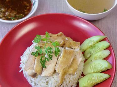 Hainanese chicken and rice with cucumber garnish
