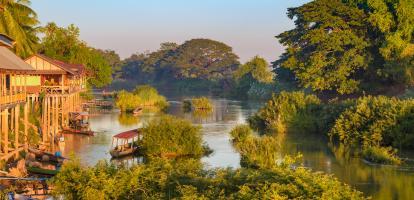 Early morning illuminates riverside houses and boats in Si Phan Don, the 4000 islands of Laos