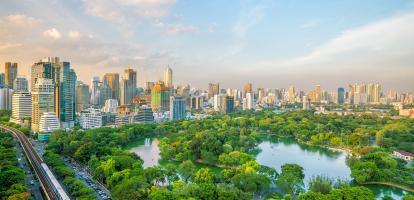 Gentle sunset over Bangkok's skyline with Lumpini Park's lush greens in the forefront