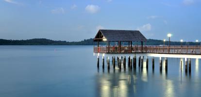 Evening reflections of jetty over lake at Changi, with gentle clouds in the sky