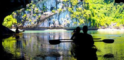 Silhouettes kayaking in Lan Ha Bay, with amazing karst rock background