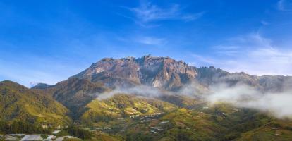 Morning on the dramatic peak of Mount Kinabalu, surrounded by clouds and lush jungle