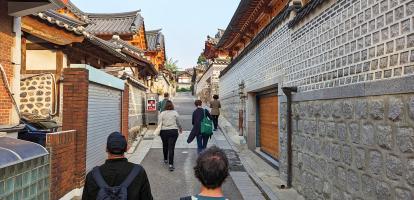 Three tourists and a guide walk through the traditional neighbourhood of Bukchon in Seoul