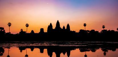 Gentle warm colors brighten the sky during sunrise in Angkor Wat temple complex in Cambodia