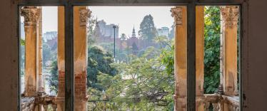 An old brick archway partially painted provides beautiful views of royal palance in Phnom Penh
