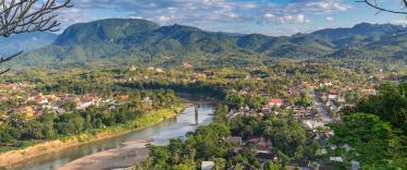 Aerial view of beautiful Luang Prabang city surrounded by jungle and sprawling alongside Nam Khan River