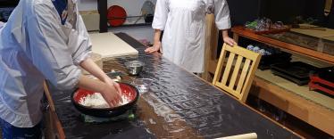 Two people preparing food on kitchen table