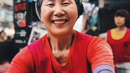 South Korean woman is smiling at the camera in a market in Seoul