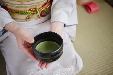 Hands holding cup of green tea