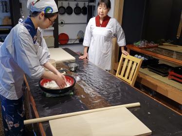 Two people preparing food on kitchen table