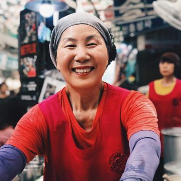 South Korean woman is smiling at the camera in a market in Seoul