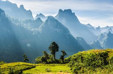 Mountain and blue sky at Kasi, Laos. and little home in grass field in front of mountain